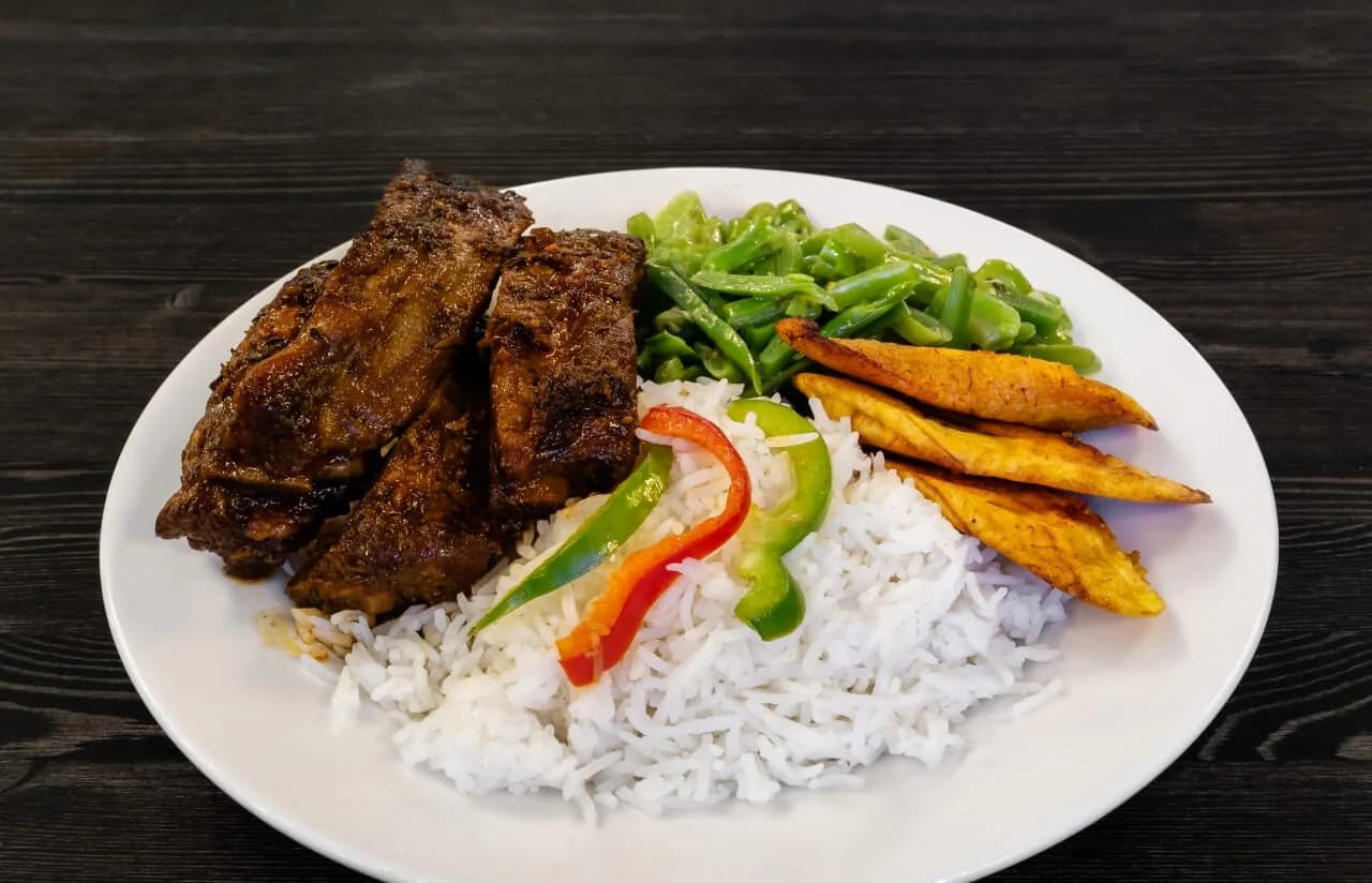 Spareribs met witte rijst, paprika en gebakken bakbanaan